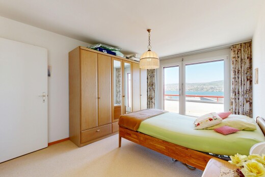 room / bedroom with light colored carpet and a water view