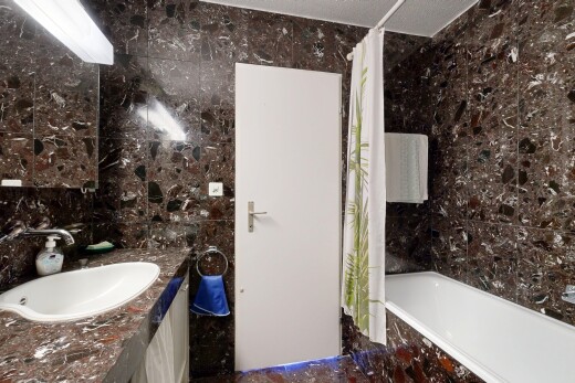 bathroom with tile walls, tiled shower / bath combo, and vanity