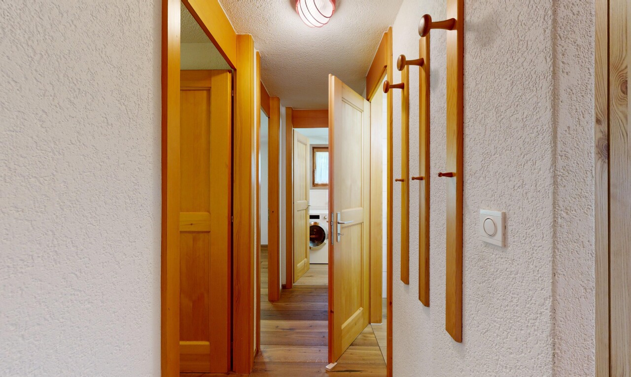 hall with a textured wall, light wood-style flooring, a textured ceiling, and washer / clothes dryer