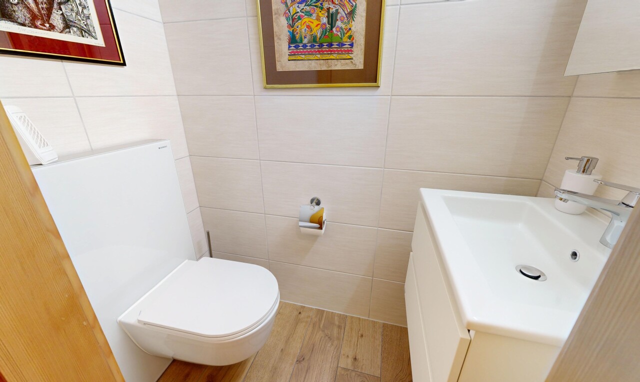 half bathroom with tile walls, vanity, and light wood-style floors