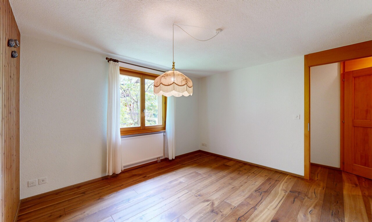 empty room with light wood-type flooring, radiator heating unit, and a textured ceiling
