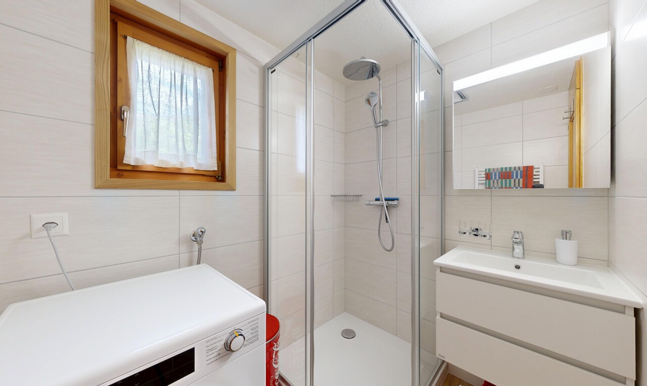 full bathroom featuring tile walls, a stall shower, vanity, washer / clothes dryer, and tasteful backsplash