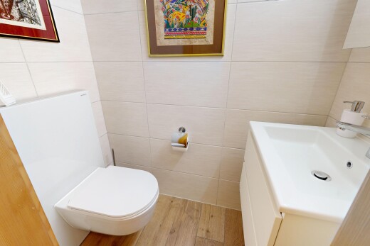 salle de bains avec mur en carrelage, tile wall, toilette, lavabo (ou coiffeuse selon le contexte), et inside property