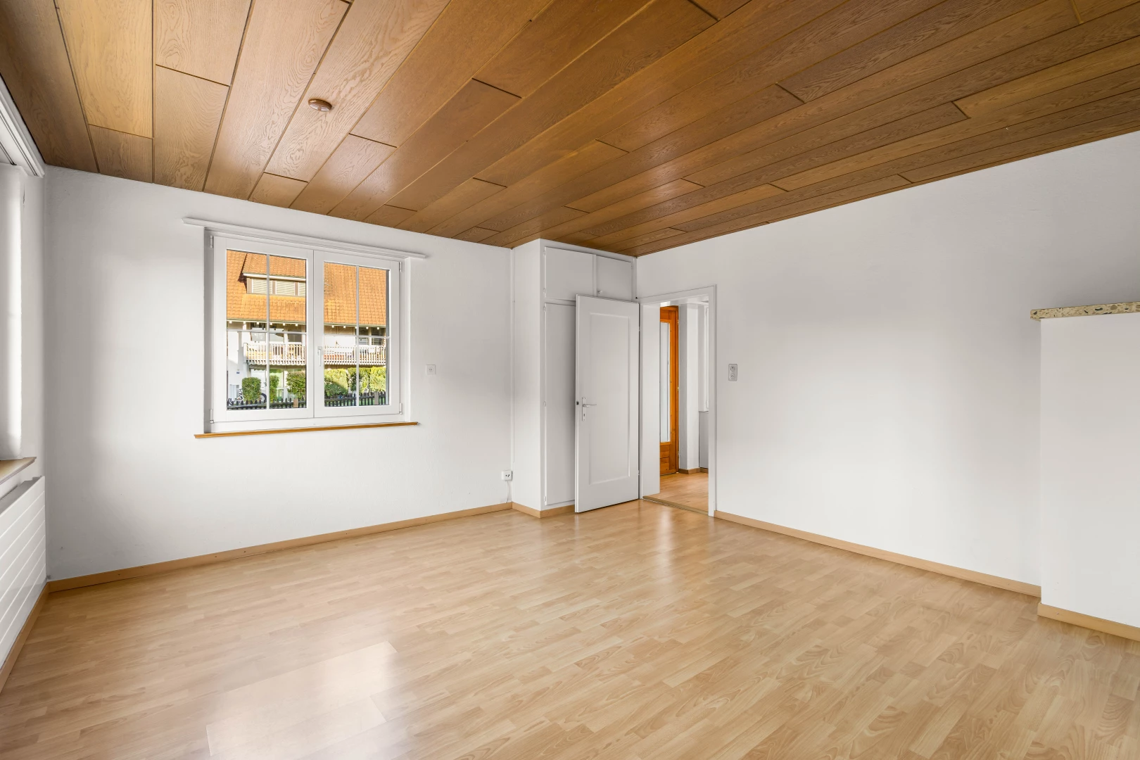 pièce vide avec plancher de bois, plafond de bois, et lumière naturelle