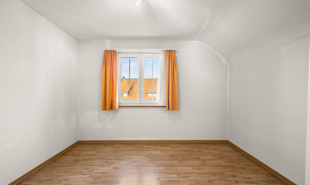 pièce vide avec plancher de bois, plafond voûté, et lumière naturelle