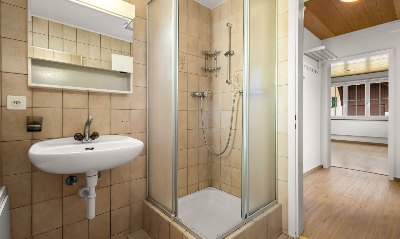 salle de bain avec vasque, douche, carrelage, mur carrelé, et plancher de bois