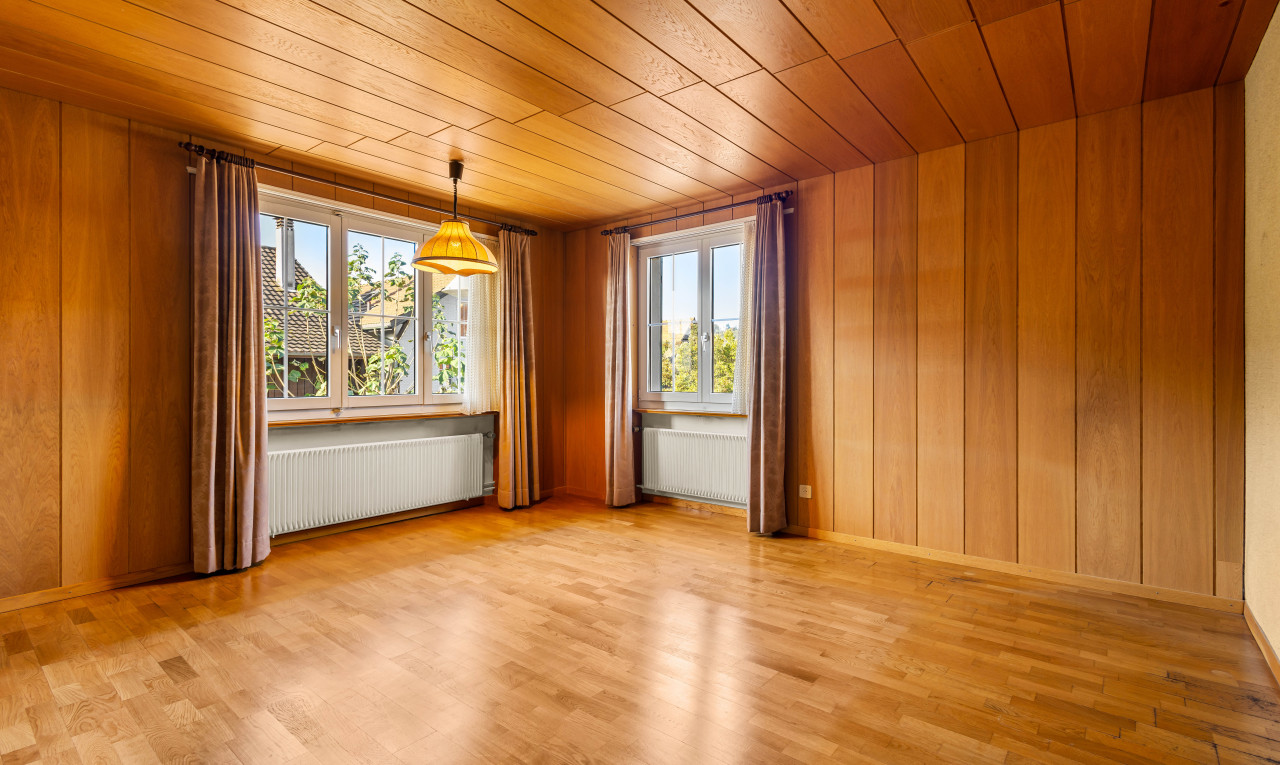 pièce vide avec lumière naturelle, plafond de bois, et radiateur