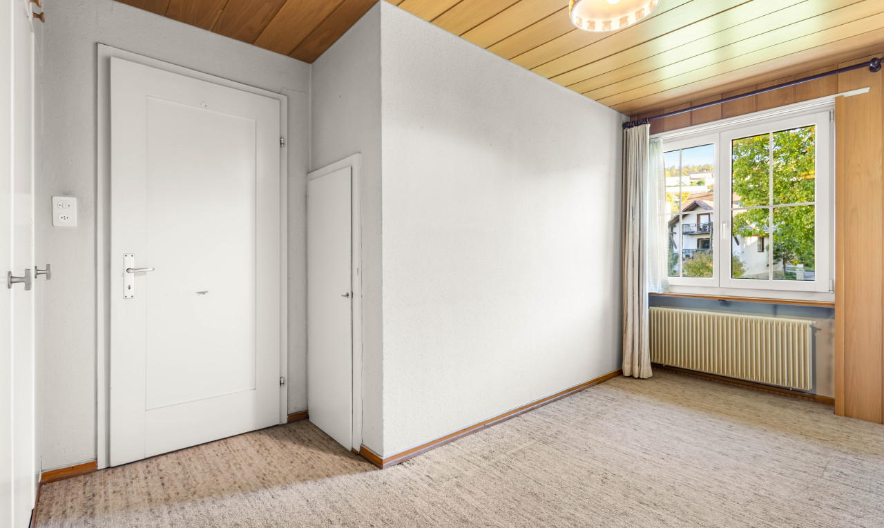 pièce vide avec lumière naturelle, plafond de bois, radiateur, et moquette