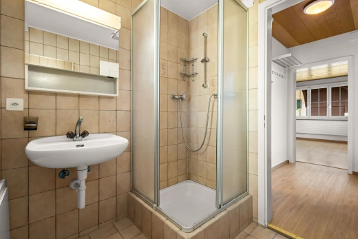 salle de bain avec vasque, douche, carrelage, mur carrelé, et plancher de bois