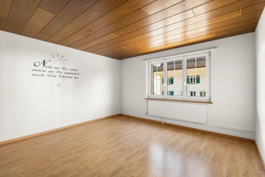 pièce vide avec plancher de bois, plafond de bois, radiateur, et lumière naturelle