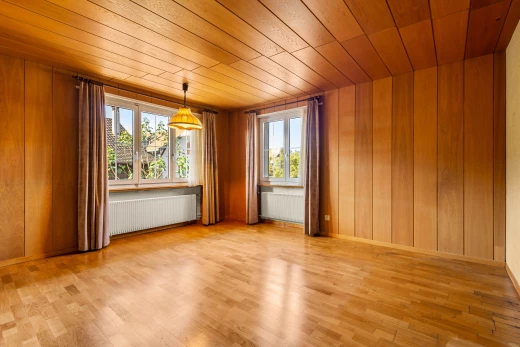 pièce vide avec lumière naturelle, plafond de bois, et radiateur