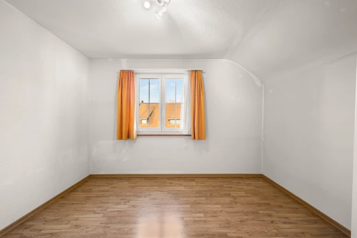 pièce vide avec plancher de bois, plafond voûté, et lumière naturelle