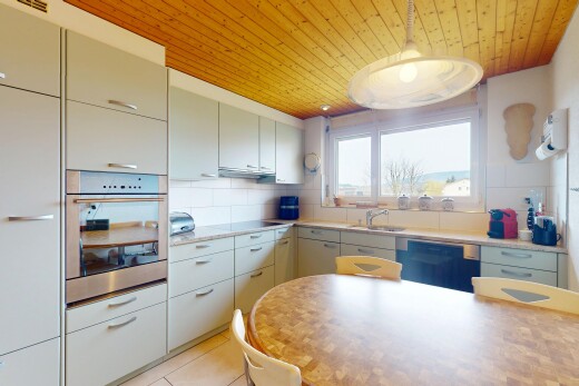 küche mit geschirrspülmaschine, holzdecke, küchenrückwand beim herd, waschbecken, und ofen