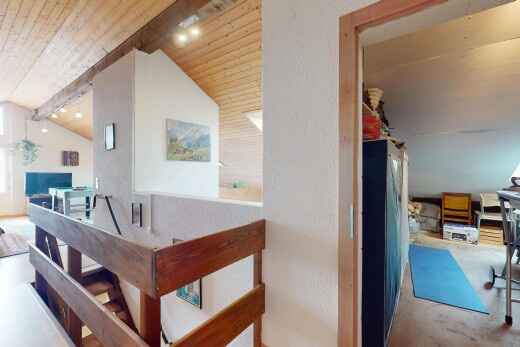 innenraum mit balkendecke, dachschräge, strukturierte wand, holzdecke, und fernseher