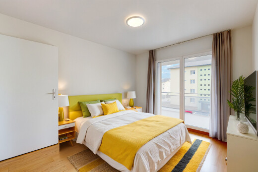 zimmer / schlafzimmer mit holzfußboden, fernseher, natürliches licht, und gipskartonwand