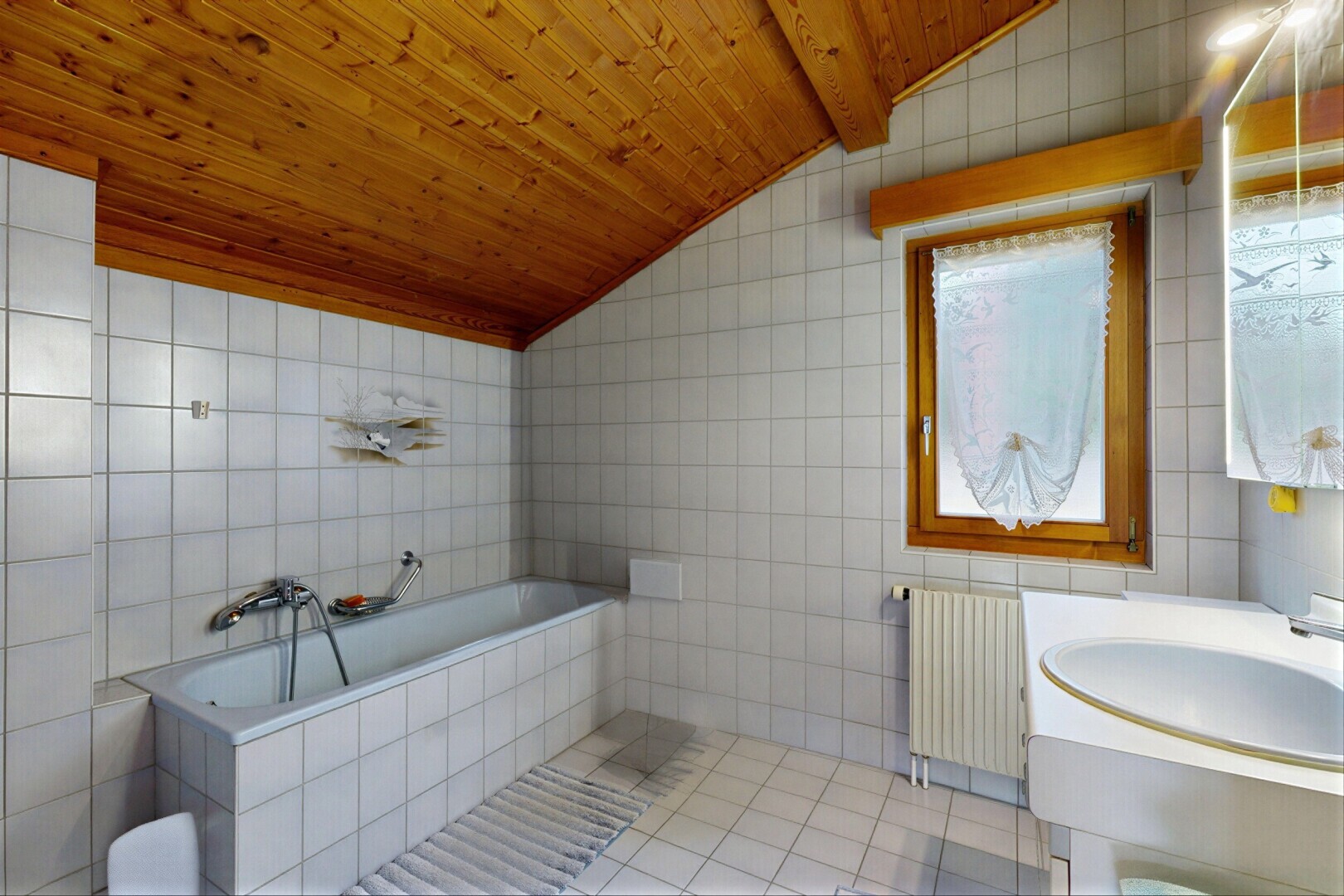 salle de bains avec mur en carrelage, tile wall, plafond voûté, vaulted ceiling, et salle de bain complète