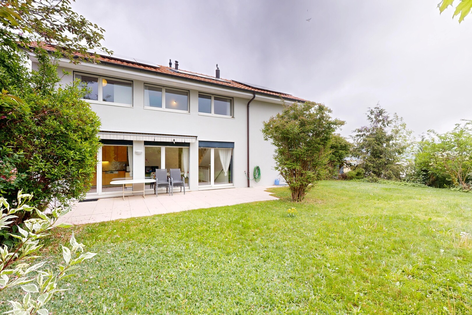 außenansicht mit overcast, rasen, property visible, stuckverkleidung, und terrasse
