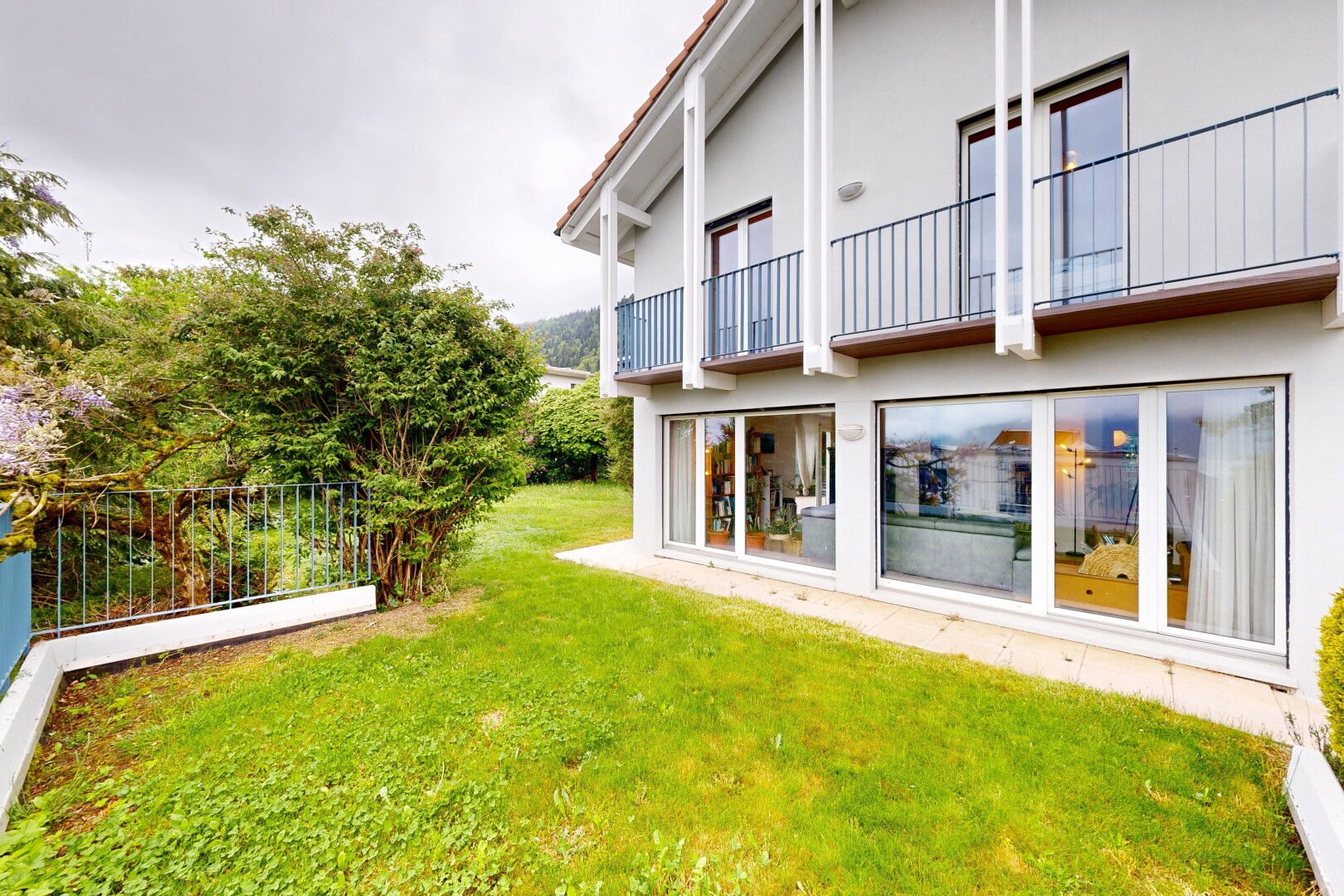 außenansicht mit balkon, from property, overcast, stuckverkleidung, und rasen
