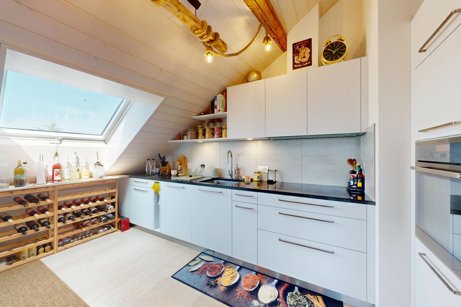 cuisine avec armoires à panneau plat, étagères ouvertes, armoires blanches, four, et lumière naturelle