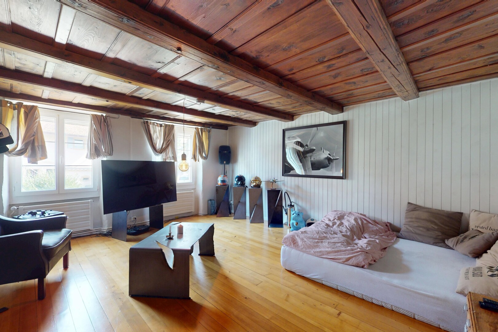 salon avec plafond à poutres, beamed ceiling, télévision, sol en finition bois, et wood finish floor