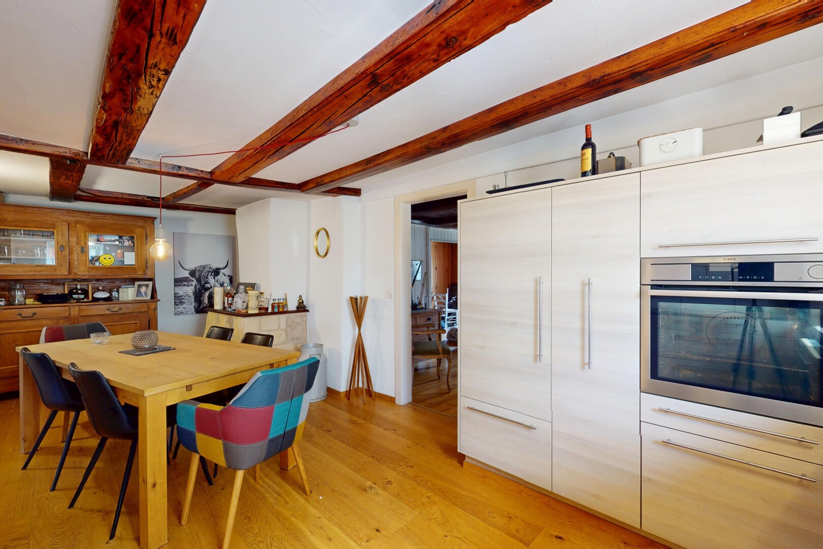 cuisine avec four, sol en finition bois, wood finish floor, plafond à poutres, et beamed ceiling
