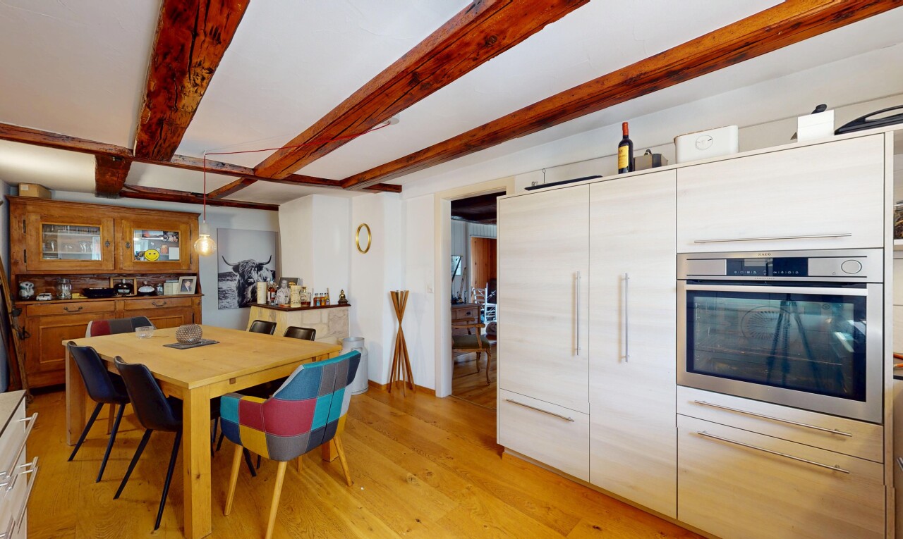 cuisine avec four, sol en finition bois, wood finish floor, plafond à poutres, et beamed ceiling