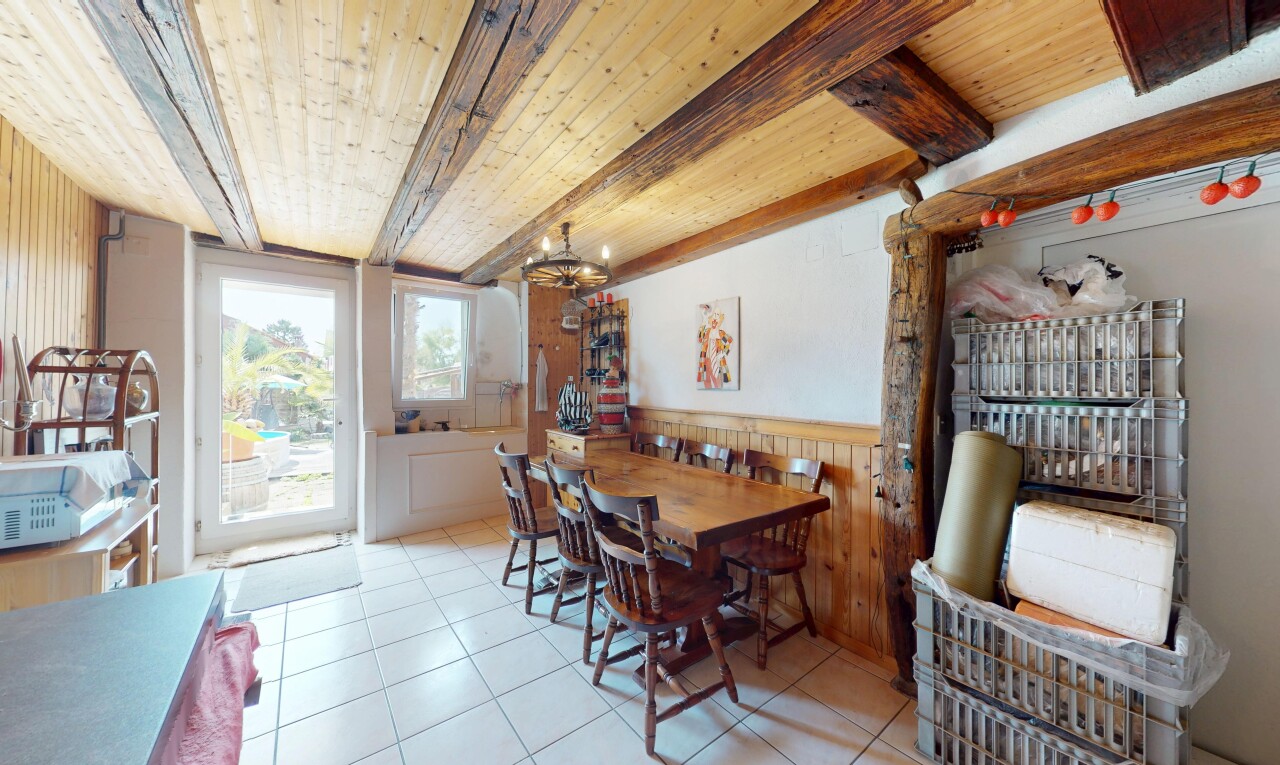 salle à manger avec plafond à poutres, beamed ceiling, mur à lambris, wainscot wall, et mur en bois