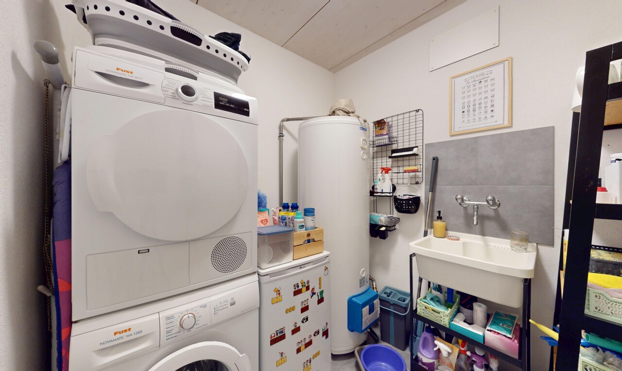 buanderie avec buanderie, chauffe-eau, lave-linge et sèche-linge superposés, inside property, et évier