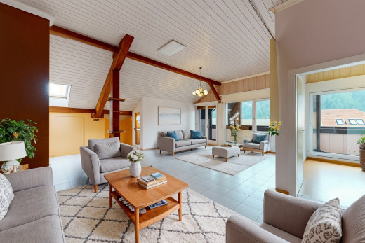 wohnzimmer mit dachschräge, balkendecke, natürliches licht, bemerkenswerter kronleuchter, und hohe decke