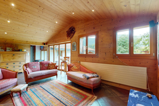 wohnzimmer mit holzdecke, dachschräge, fliesenboden, natürliches licht, und holzwand