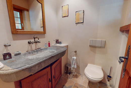 bad mit toilette, spiegel, waschbeckenunterschrank, fliesenboden, und natürliches licht