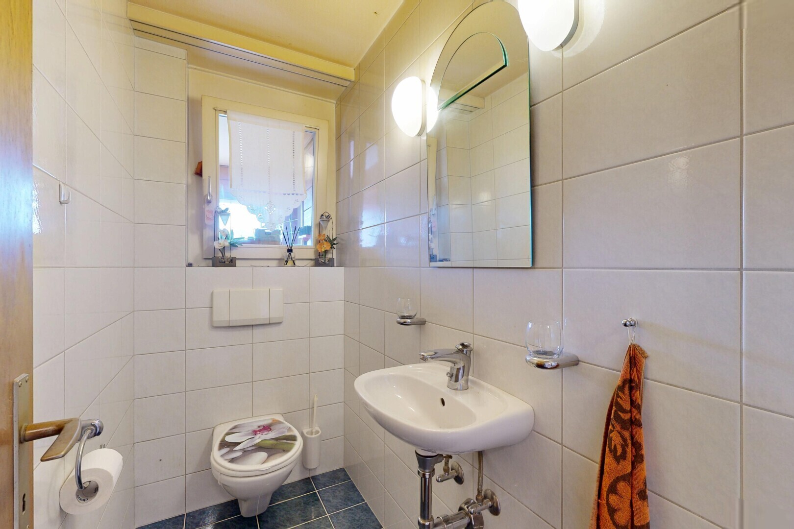 salle de bains avec mur en carrelage, tile wall, miroir, toilette, et sol en carrelage
