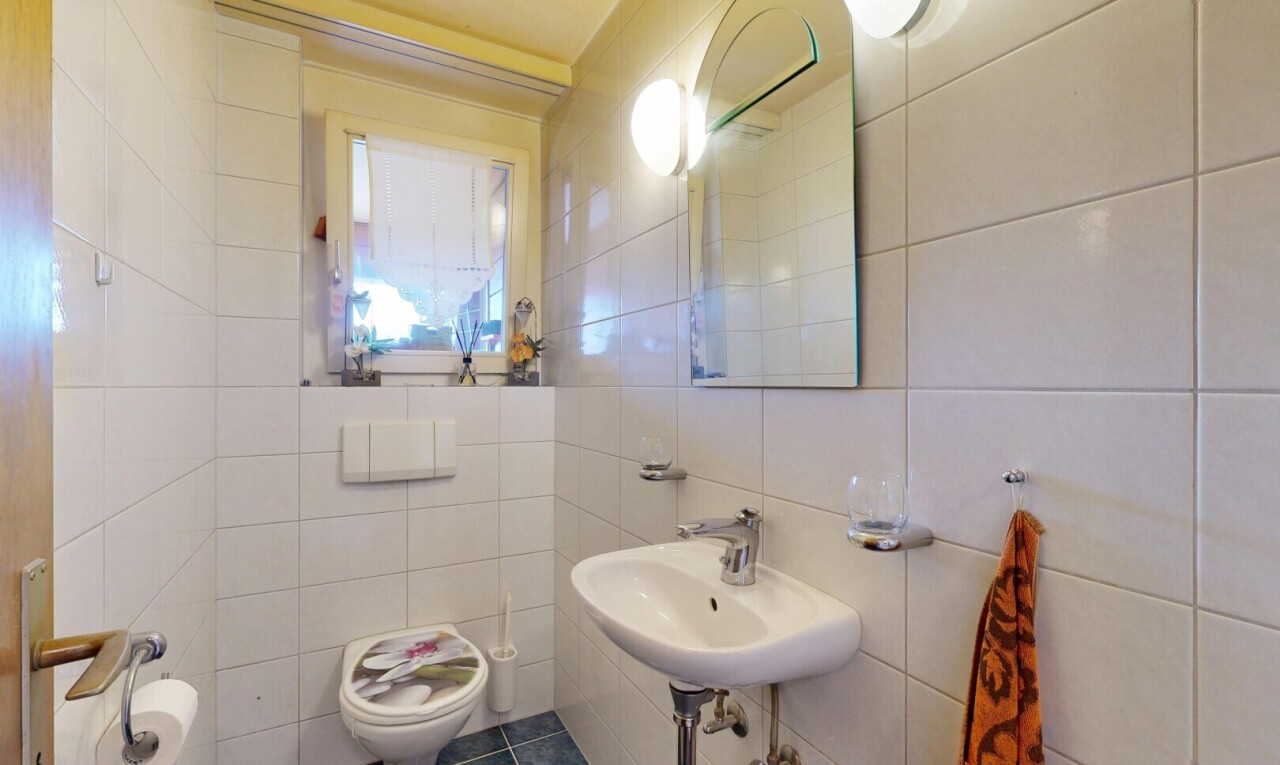 salle de bains avec mur en carrelage, tile wall, miroir, toilette, et sol en carrelage