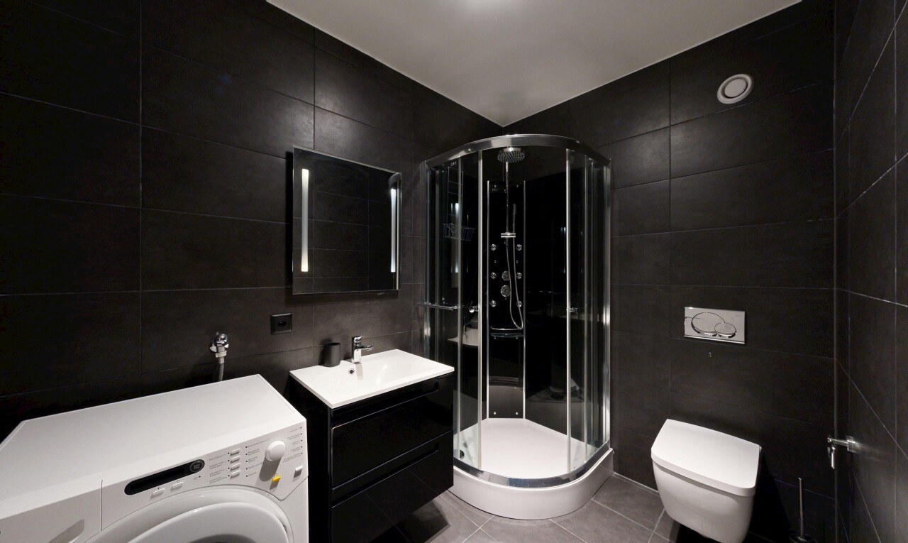 salle de bains avec tile wall, mur en carrelage, lave-linge et sèche-linge, lavabo (ou coiffeuse selon le contexte), et light floor