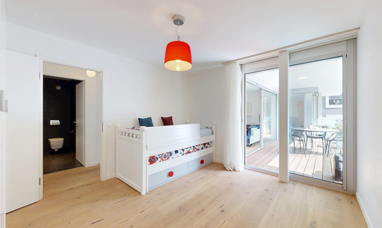 chambre avec wood finish floor, sol en finition bois, accès à l'extérieur, drywall, et cloison sèche