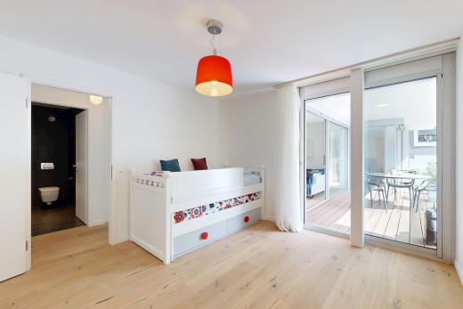 chambre avec wood finish floor, sol en finition bois, accès à l'extérieur, drywall, et cloison sèche