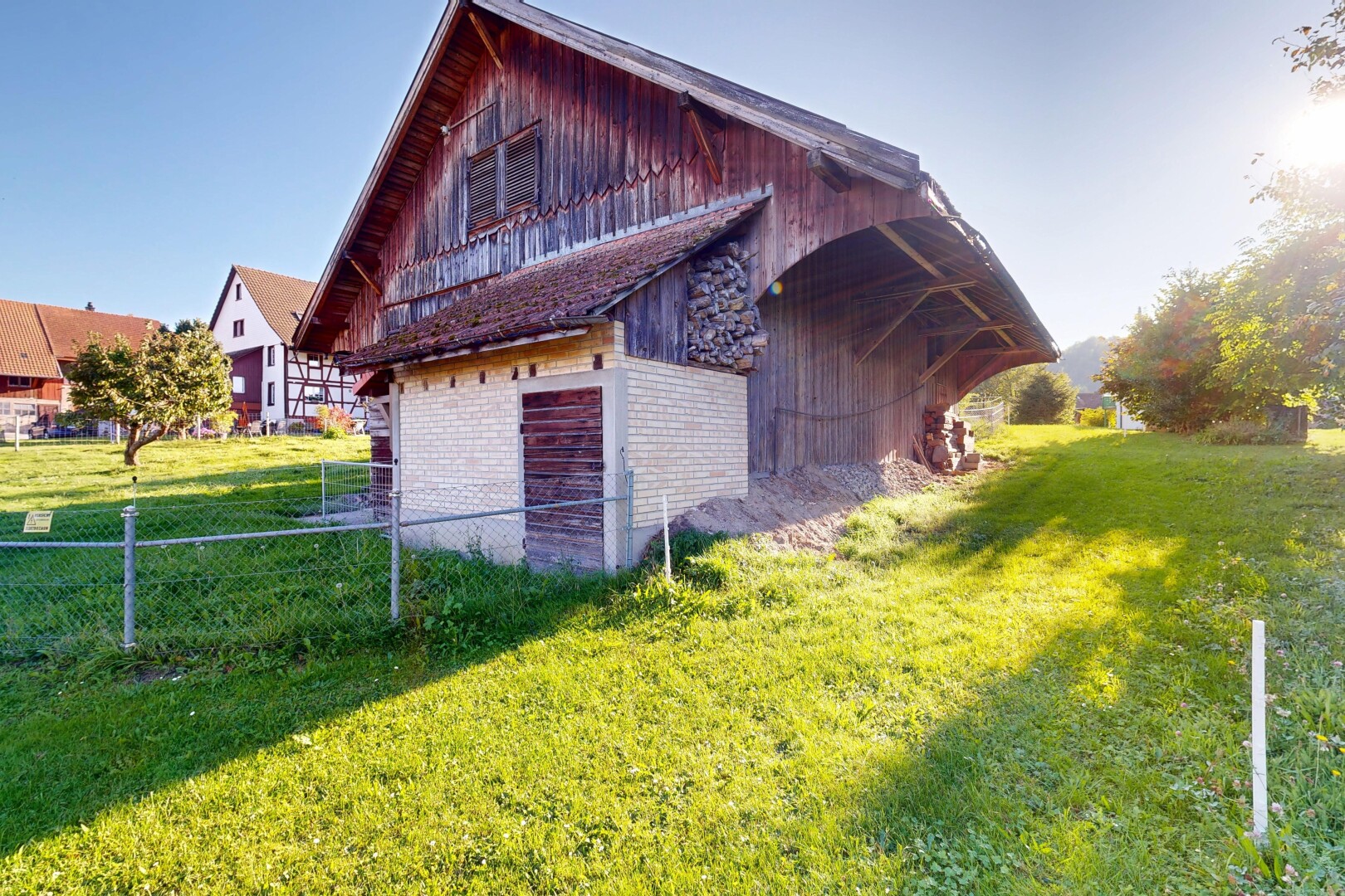 view of property with brick siding, a barn, and an outbuilding