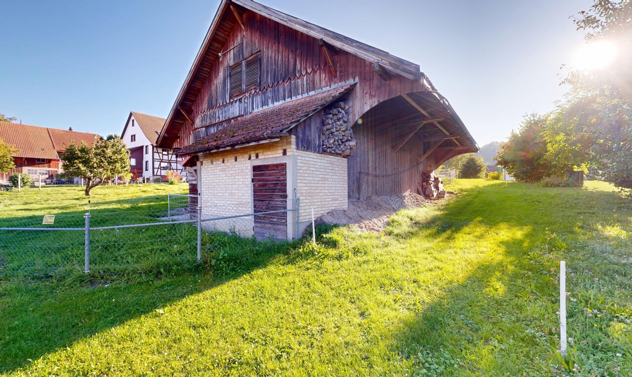view of property with brick siding, a barn, and an outbuilding