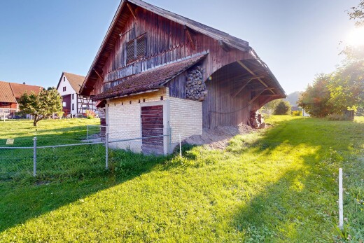 façade avec bardage en brique, grange, pelouse, structure extérieure, et bardage vertical