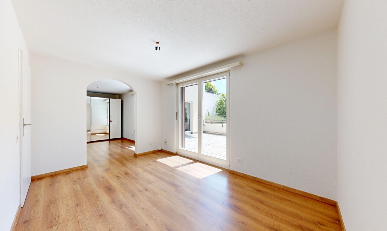 leerer raum mit gewölbte gehwege, gipskartonwand, drywall, inside property, und holzfußboden