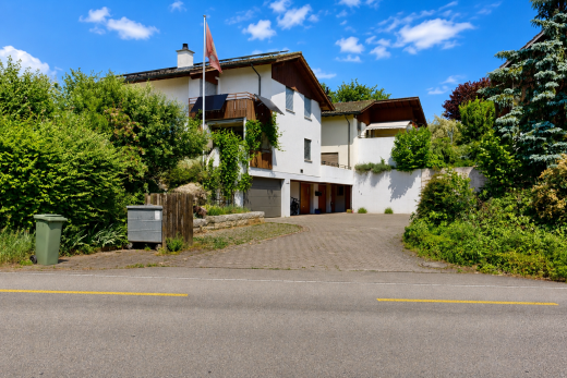 façade avec balcon, bardage en stuc, garage intégré, day time, et allée