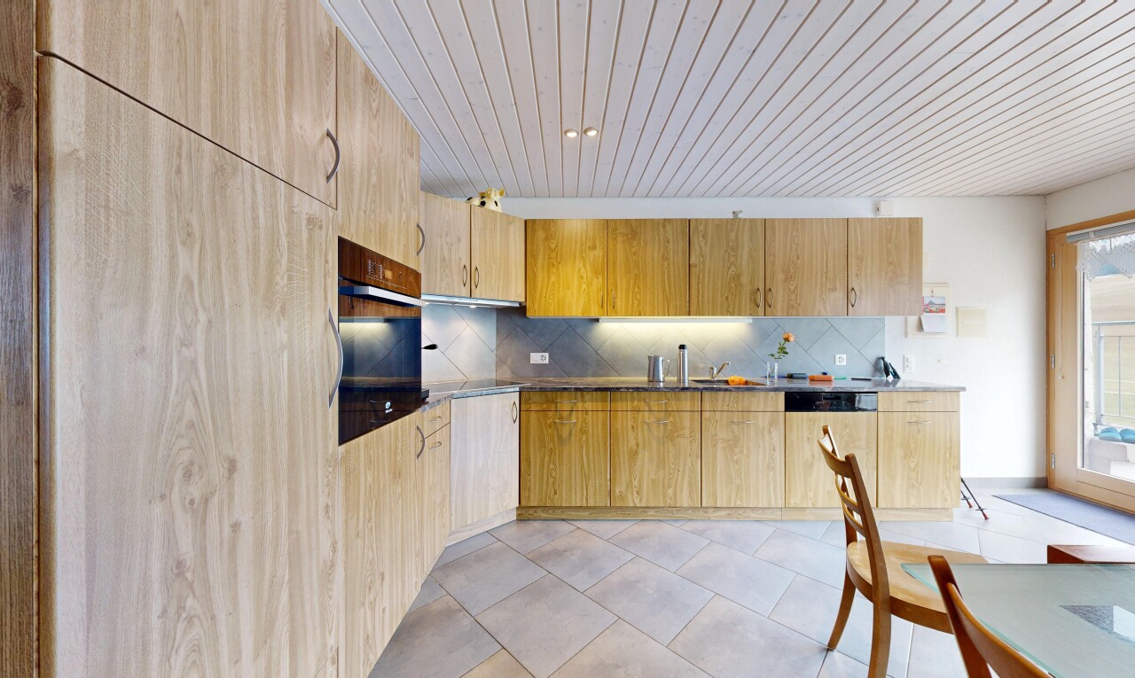kitchen with light wood finish cabinets, oven, dark countertops, dishwasher, and backsplash