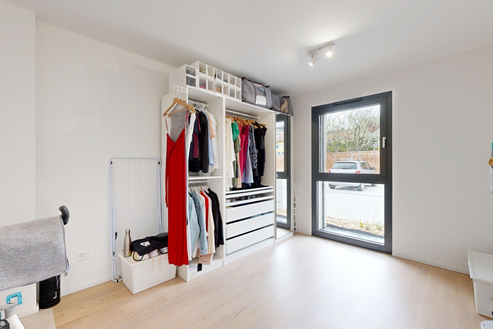 walk in closet with light wood-style floors