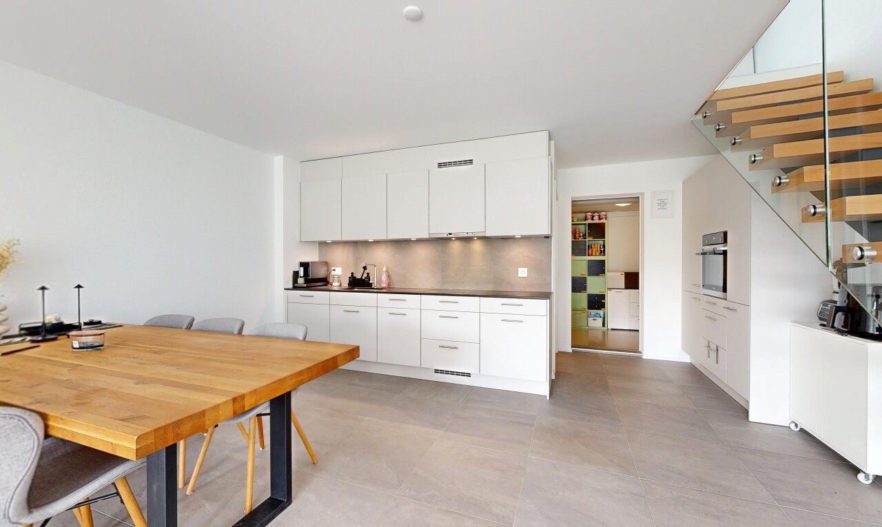 kitchen with dark countertops, concrete floors, oven, and white cabinets