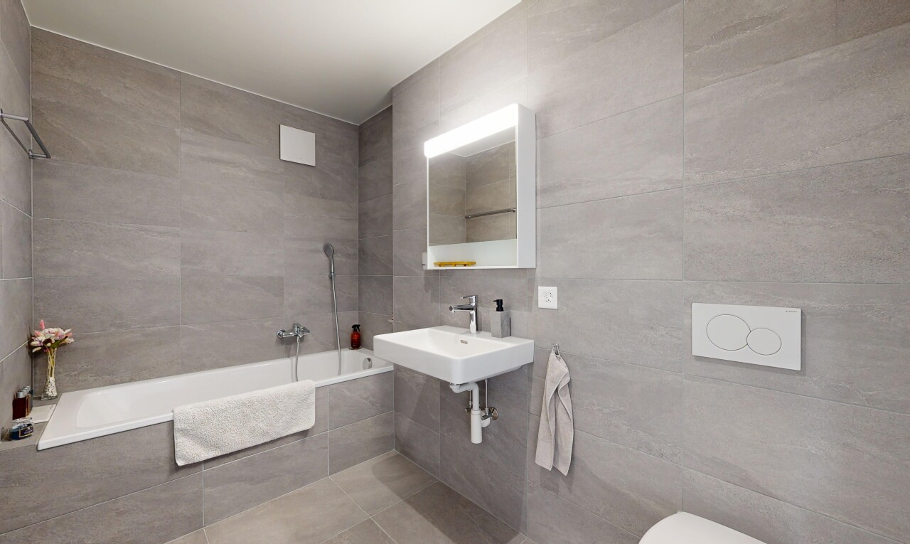 bathroom featuring tile walls and tiled shower / bath