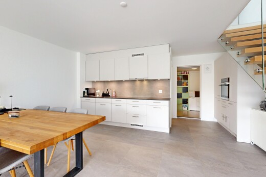 cuisine avec concrete tile, light floor, drywall, cloison sèche, et dark countertops