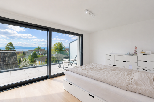 room featuring access to exterior, light wood-style floors, and rail lighting