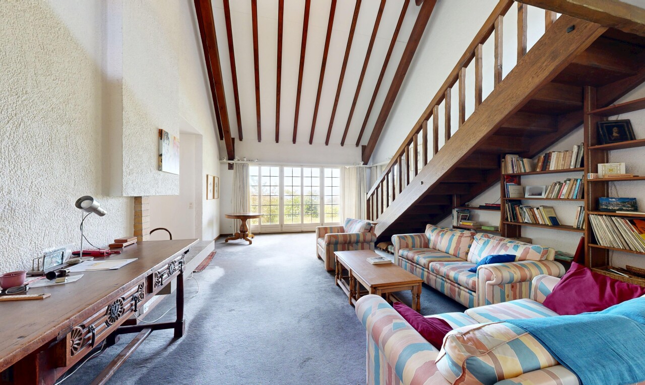 salon avec escaliers, high ceiling, plafond haut, carpet, et moquette