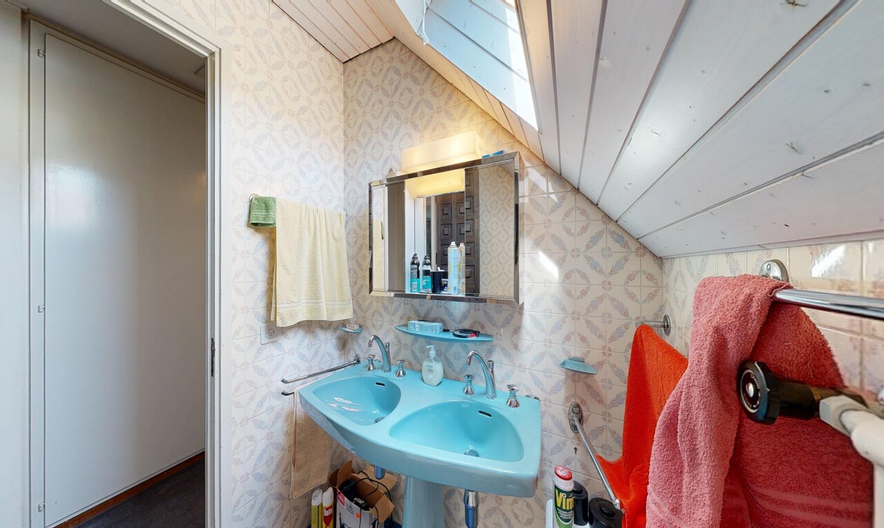 salle de bains avec miroir, mur en papier peint, wallpaper wall, plafond voûté, et vaulted ceiling