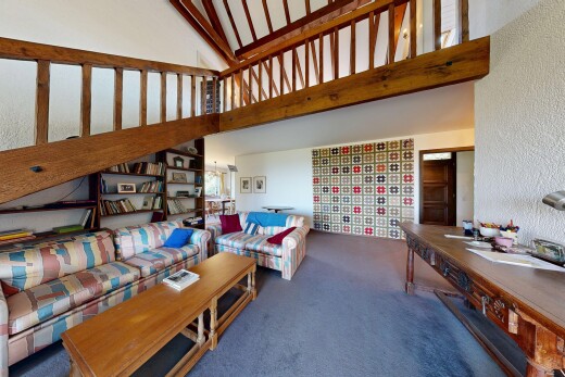 living area featuring a high ceiling, carpet, and built in shelves